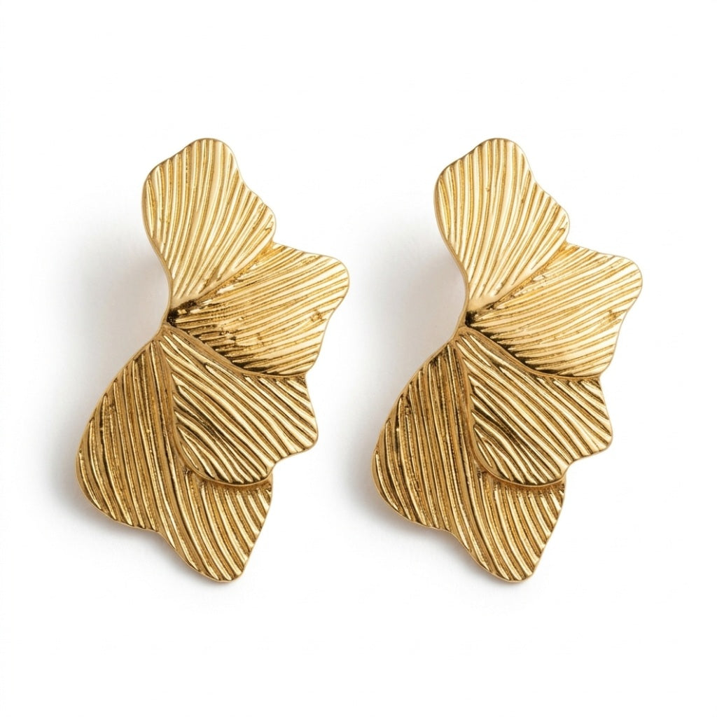 Lundholm Linden ginkgo blad oorbellen goudkleurig, twee identieke statement oorstekers op wit