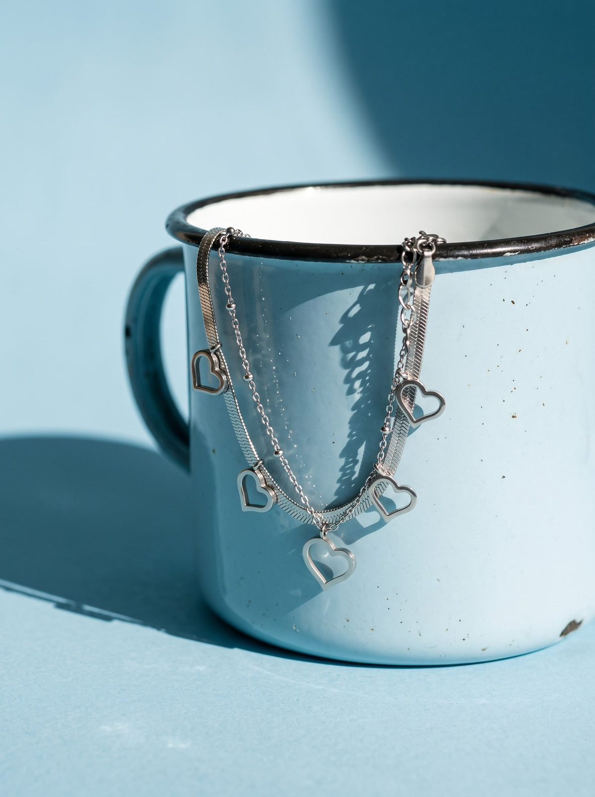 Lundholm Liv dubbele schakelarmband met hartjes zilverkleurig aan een lichtblauwe emaille mok