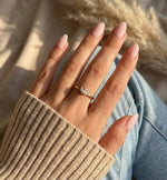 Lundholm Lotus ring met drie zirkonia steentjes in goudkleurig, verstelbaar gedragen aan vrouwenhand