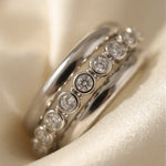 Close-up van de rij ronde zirkonia steentjes van de Lundholm Luce ring zilver op satijn