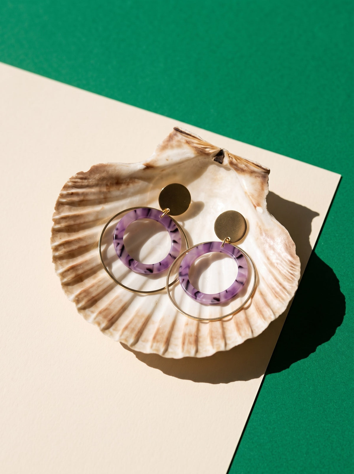 Lundholm Lucienne statement oorhangers met lila ring goudkleurig in een sint-jakobsschelp