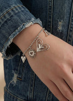 Lundholm luxe schakelarmband My Love met hartjes bedels in zilverkleurig, gedragen aan vrouwenpols