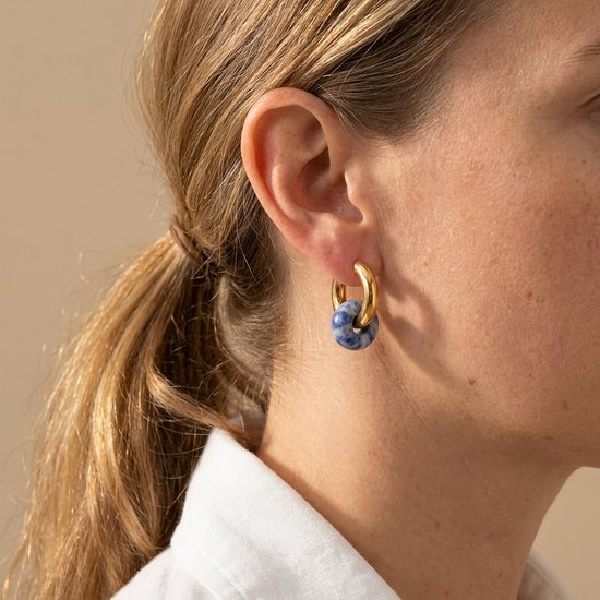 Lundholm Mabel blauwe natuursteen oorbellen gedragen – goudkleurige hoops met steen