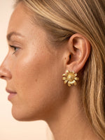 Vrouw draagt Lundholm Marguerite zilver daisy oorbel — happy daisy statement op het oor lifestyle