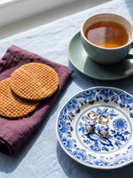 Lundholm Marie oorringen met Delfts blauw hartje goudkleurig op een Delfts blauw schoteltje bij stroopwafels en thee