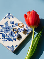 Lundholm Marie oorringen met Delfts blauw hartje goudkleurig op een Delfts blauwe tegel met een rode tulp