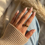 Lundholm Orion verstelbare statement ring met drie tijgeroog stenen in goudkleurig, gedragen aan vrouwenhand