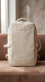 Lundholm Underseater rugzak beige reisrugzak met TSA-slot op leren bank in interieur, Scandinavisch design handbagage
