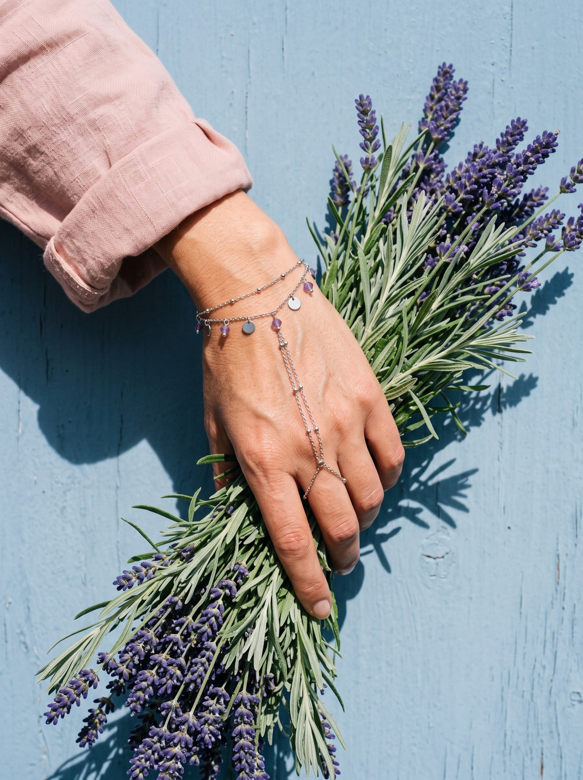 Lundholm Saar handsieraad met amethist zilverkleurig gedragen, hand met een bos lavendel