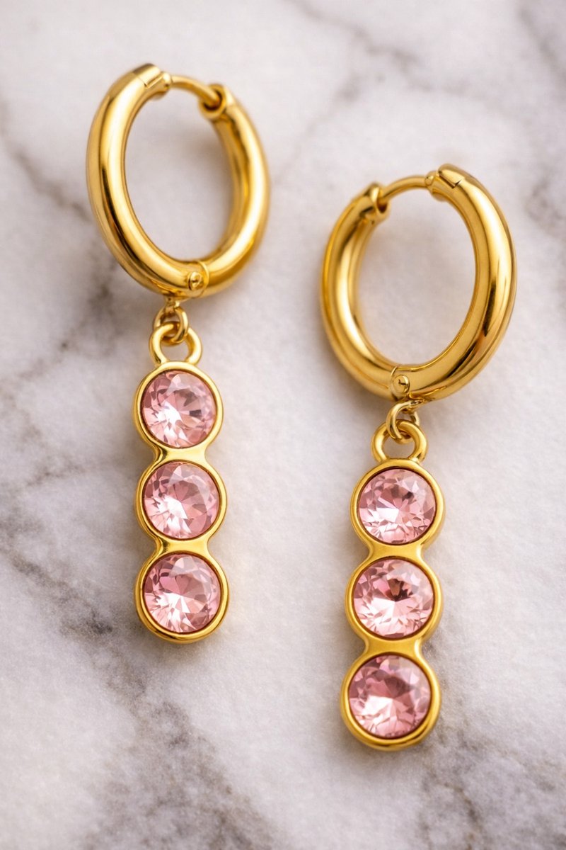 Lundholm Sam creolen oorbellen met roze zirkonia steentjes hangers in goudkleurig op marmer, productfoto