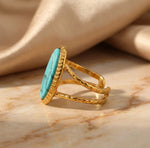 Lundholm Sienna verstelbare cuff ring met blauwe turkoois natuursteen in goudkleurig op marmer, productfoto