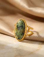 Lundholm Sienna verstelbare cuff ring met grote groene natuursteen in goudkleurig op satijn, productfoto