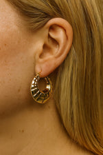 Lundholm Skye oorringen goudkleurig gedragen – statement hoops met reliëf