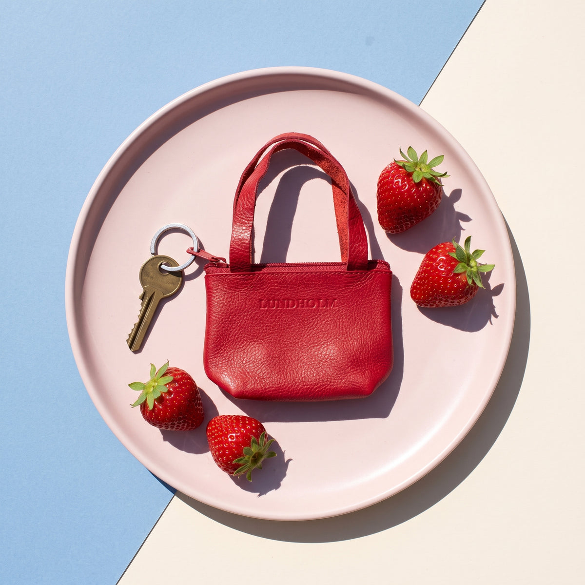 Lundholm sleuteletui rood mini shopper op een roze bord met aardbeien