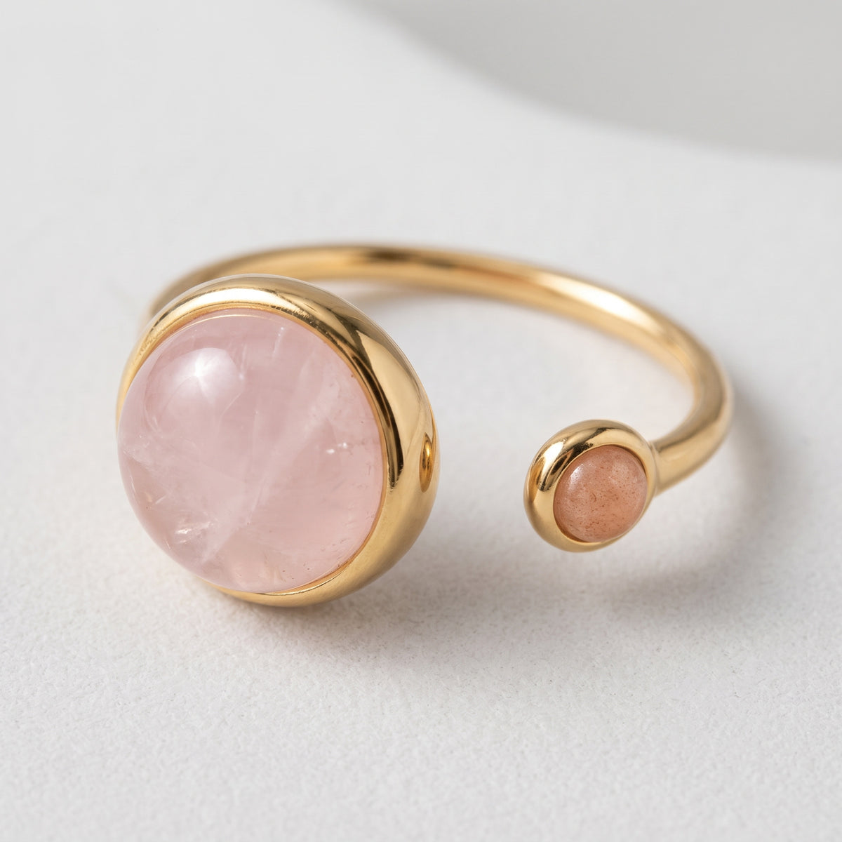 Lundholm Sophia ring met rozenkwarts en zonnesteen — vooraanzicht, verstelbaar, goudkleurig PVD stainless steel