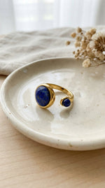 Lundholm Sophia ring met lapis lazuli blauwe edelsteen op keramisch schaaltje, goudkleurig 18K verguld stainless steel verstelbare ring lifestyle