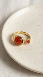 Lundholm Sophia ring met rode agaat edelsteen op keramisch schaaltje, goudkleurig 18K verguld stainless steel verstelbare ring lifestyle
