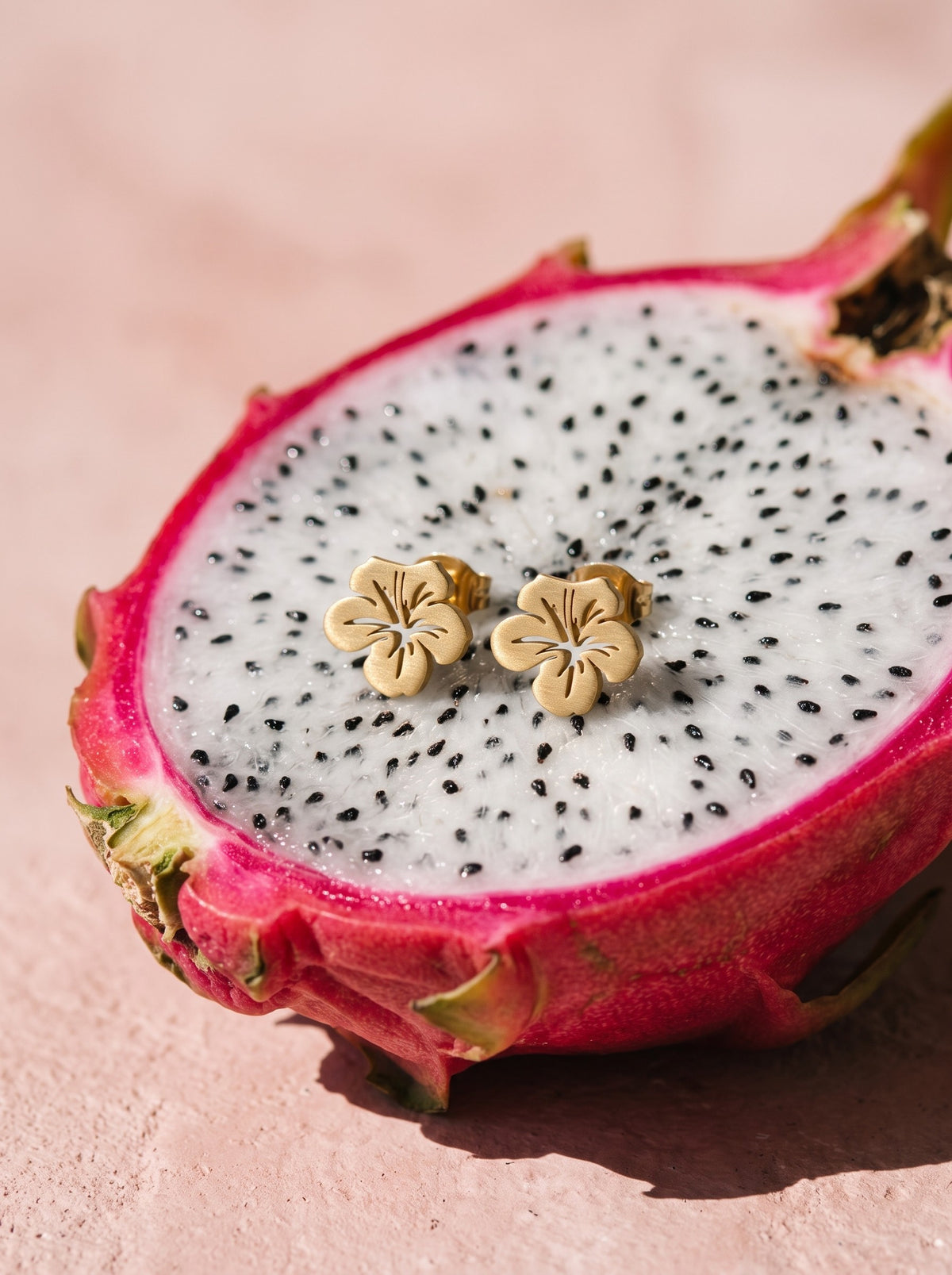 Lundholm Tropicana hibiscus oorknopjes goudkleurig op een halve dragonfruit