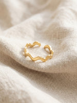 Lundholm Zia ring goud detail – golvende zigzag band op linnen