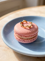 Lundholm Zia zigzag ring goudkleurig op een roze macaron